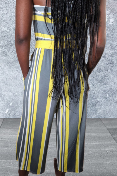 Person wearing a striped outfit with yellow and gray vertical stripes against a gray background