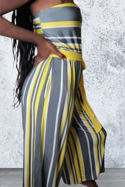 Person wearing a striped outfit with wide-leg pants against a textured wall.