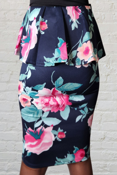 Navy blue skirt with pink floral pattern against a white brick wall